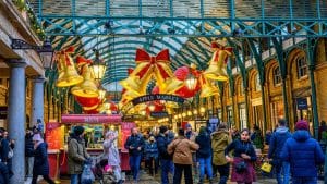 People walking through a festive market with christmas decorations.