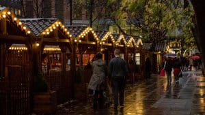 people walking on sidewalk near brown wooden building during night time