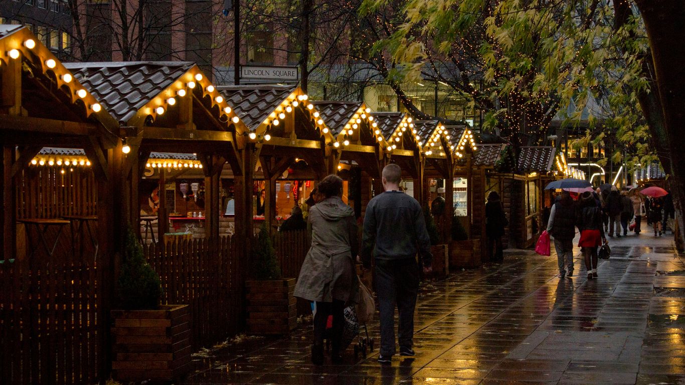 people walking on sidewalk near brown wooden building during night time